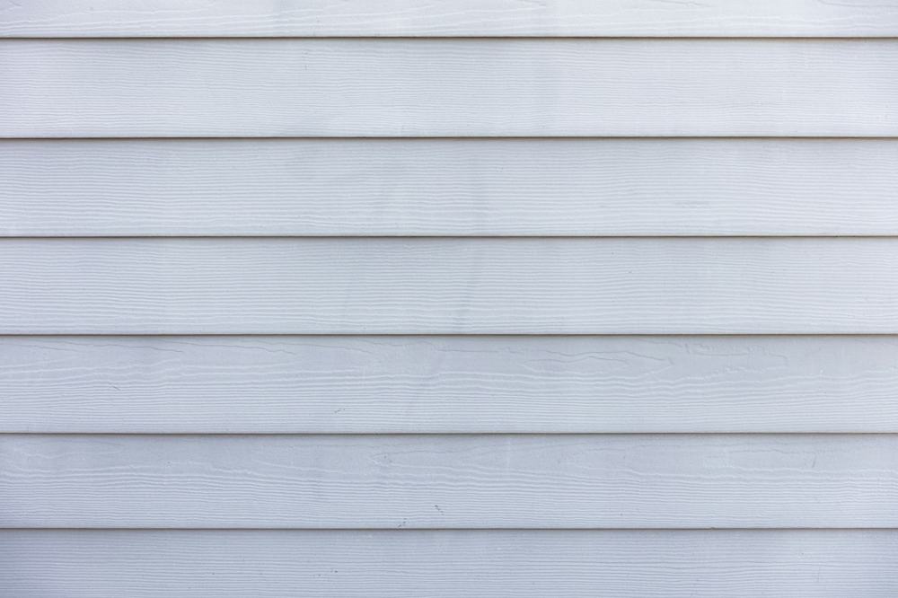 Close-up of clean white lap siding with even horizontal shadow lines